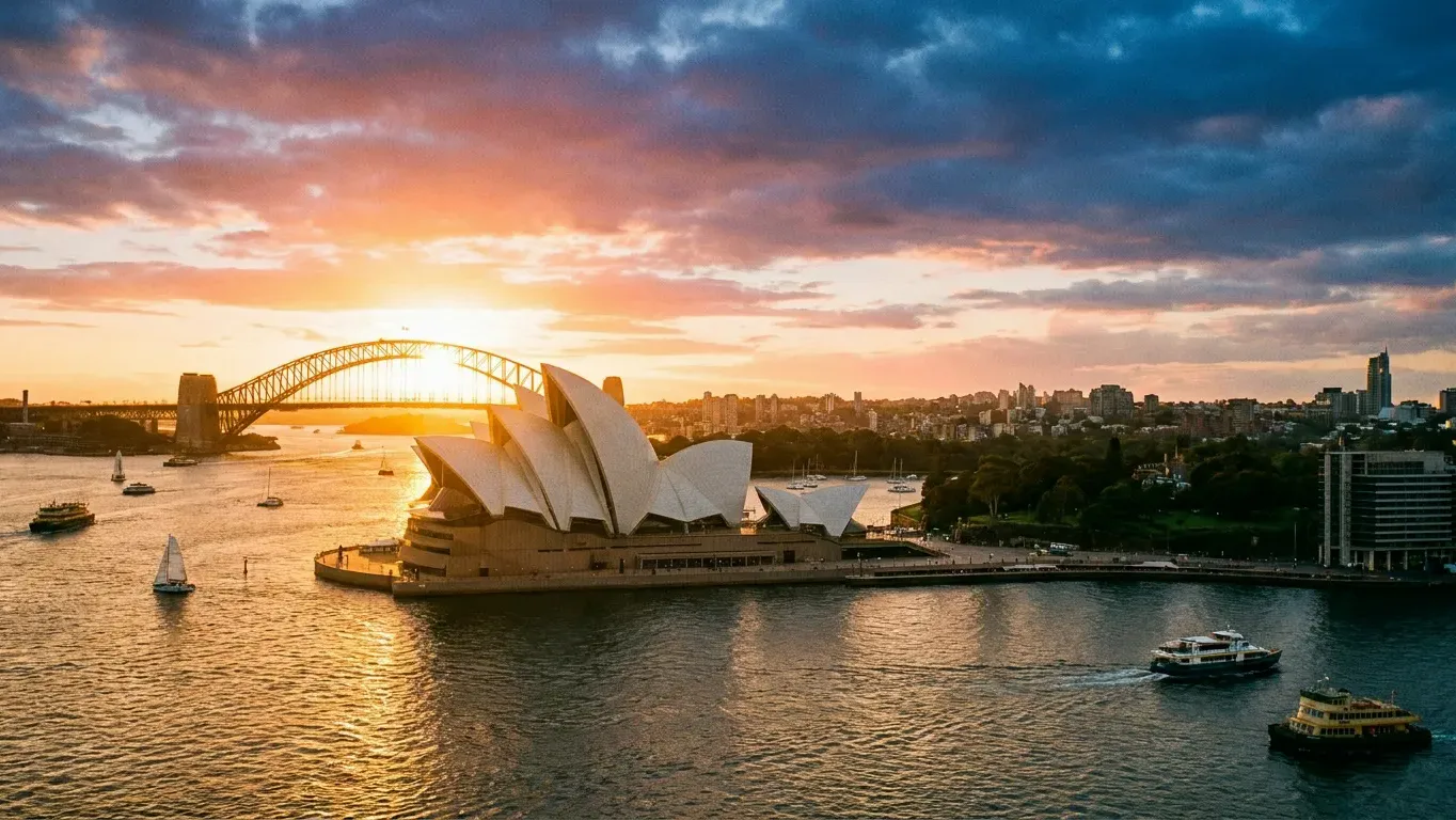 Sydney Harbour at sunset with the Opera House and Harbour Bridge silhouetted against an amber sky — Australia raises its student visa application charge for international students from July 2026